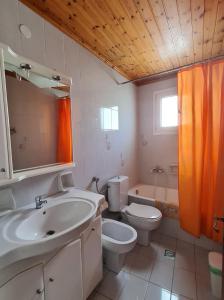 a bathroom with a sink and a toilet and a tub at Avdikos House in Parga