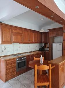 a kitchen with wooden cabinets and a wooden table with a wooden table at Avdikos House in Parga