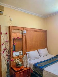 una camera con letto e specchio di Rumah palala a Kampungdurian