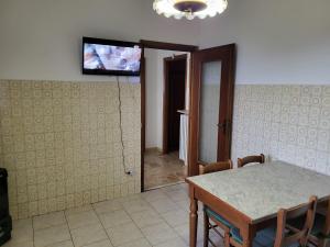 ein Esszimmer mit einem Tisch und einem TV an der Wand in der Unterkunft Villa Zene in Montù Beccaria