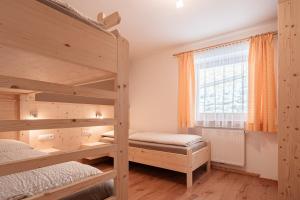 a bedroom with two bunk beds and a window at Lüch da Morgnun in San Vigilio Di Marebbe