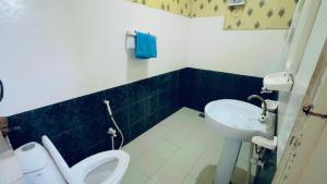 y baño con aseo y lavamanos. en Pramier Inn Near Agha Khan Hospital, en Karachi