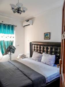 Un dormitorio con una cama grande y un ventilador de techo. en Gifted Apartment & Residence, en Abuja