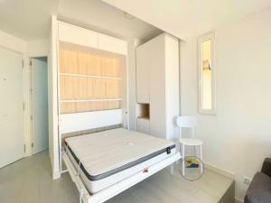 ein weißes Zimmer mit einem Bett und einem Stuhl in der Unterkunft Modern studio apartment at Monaco,La Manga in La Manga del Mar Menor