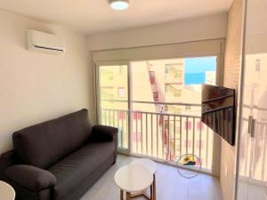 ein Wohnzimmer mit einem Sofa und einem Balkon in der Unterkunft Modern studio apartment at Monaco,La Manga in La Manga del Mar Menor