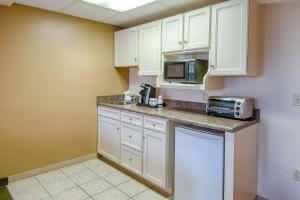 a kitchen with white cabinets and a microwave at Park Tower Inn in Pigeon Forge