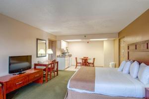 a hotel room with a bed and a flat screen tv at Park Tower Inn in Pigeon Forge