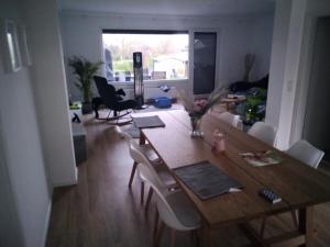 - un salon avec une table et des chaises en bois dans l'établissement Herrmannsruh - b45555, à Neustadt in Holstein