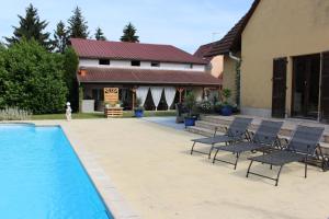 a patio with chairs and a pool in front of a house at Agrita Home in Wittisheim