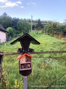 ein Vogelhaus auf einem Zaun in der Unterkunft BnB LES OISEAUX, chez Claude et Lidia, 26 à 44m2, 2ème étage in Vendlincourt