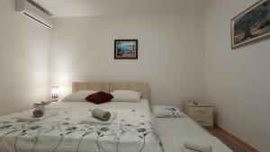 a bedroom with a bed with two towels on it at Apartment Relax in Mokošica