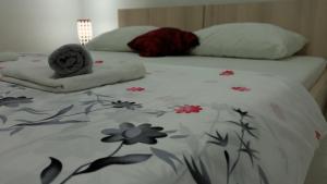 a bed with a blanket with flowers on it at Apartment Relax in Mokošica