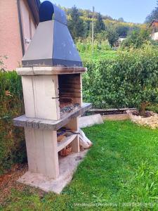 einen Backsteinofen, der im Gras im Hof sitzt in der Unterkunft BnB LES OISEAUX, chez Claude et Lidia, 26 à 44m2, 2ème étage in Vendlincourt