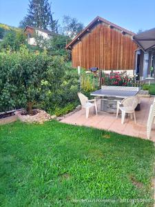 eine Terrasse mit einem Tisch und Stühlen im Hof in der Unterkunft BnB LES OISEAUX, chez Claude et Lidia, 26 à 44m2, 2ème étage in Vendlincourt