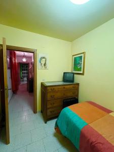 een slaapkamer met een bed en een dressoir met een televisie erop bij Villa Angelina holidays in Ripa Teatina