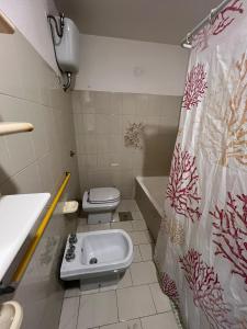 een badkamer met een toilet, een wastafel en een douchegordijn bij Villa Angelina holidays in Ripa Teatina