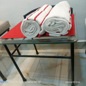 two towels sitting on top of a glass table at The King's Castle in Guwahati