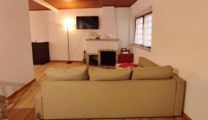 a living room with a couch and a television at Casas da Biquinha in Sintra