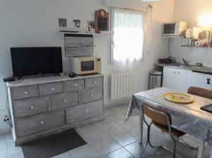 a kitchen with a dresser with a tv on top of it at Grand studio sur jardin Nantes Beaujoire B in Nantes