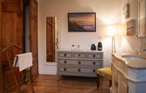 a bathroom with a sink and a dresser at Le Colombier in Wissant