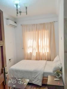 a bedroom with a large bed with a window at Gifted Apartment & Residence in Abuja