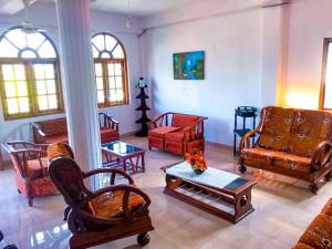 a living room with couches and chairs and a table at Geesh Residence : Rooms in Jaffna in Jaffna