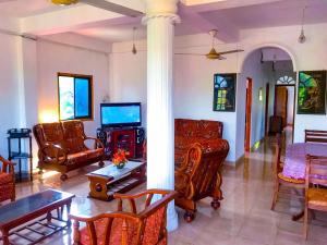 a living room with a couch and chairs and a tv at Geesh Residence : Rooms in Jaffna in Jaffna