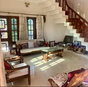 een woonkamer met een bank en een tafel bij Snow Biscuit Villa in Dharamshala