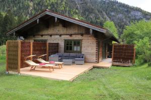 Cabaña con terraza con sofá y mesa en Chalets & Apartments Beim Waicher, en Ruhpolding