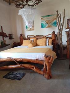 a bedroom with a bed made out of tree logs at SD3M ART GALLERY Villa in Dickwella