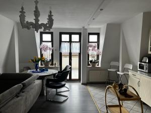 sala de estar con sofá, mesa y sillas en Villa Hirsch en Gera