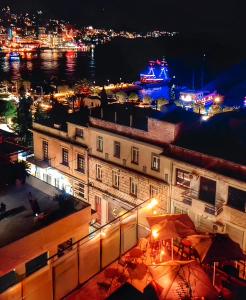 a view of a city at night with a ship at Jonian Boutique Hotel in Sarandë