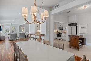 une salle à manger et une cuisine avec une table et des chaises blanches dans l'établissement The Cottage, à Santa Rosa Beach