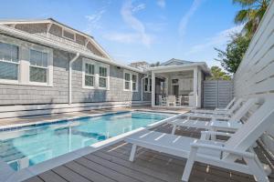 une maison avec une piscine et deux chaises sur une terrasse dans l'établissement The Cottage, à Santa Rosa Beach