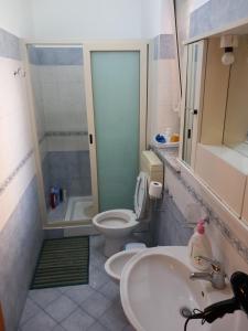 uma casa de banho com um lavatório e um WC em La casetta sul mare em Venetico