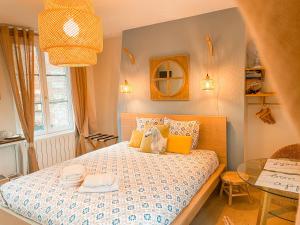 a small bedroom with a bed and a table at Clementines House Honfleur in Honfleur