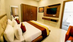 a bedroom with a large bed and a television at Hotel Amar Vilas in Bharatpur