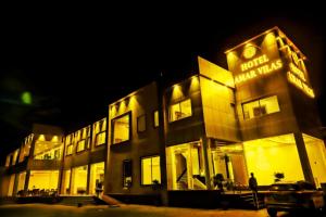 Un edificio illuminato con un uomo davanti di Hotel Amar Vilas a Bharatpur