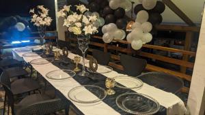 uma mesa longa com uma toalha de mesa branca e balões em Namaste hotel & restaurant em Libreville