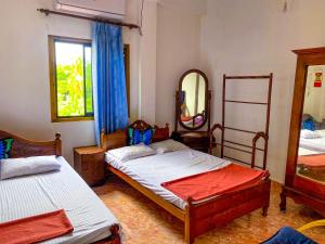 a bedroom with two beds and a mirror at Geesh Residence : Rooms in Jaffna in Jaffna