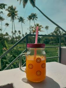 un frasco de cristal de zumo de naranja con paja rosa en Marari Bobans villa, en Mararikulam