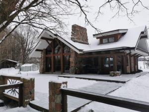 a house with snow on the roof at Ąžuolas in Kaspariškė