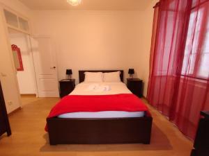 a bedroom with a bed with a red blanket at Casas da Biquinha in Sintra
