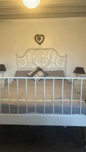 een bed met een wit bedframe en 2 lampen bij Dream Cottage in Ballintober