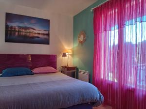 1 dormitorio con 1 cama con cortinas rosas y ventana en Chambres Tricastine & Venise en Saint-Paul-Trois-Châteaux