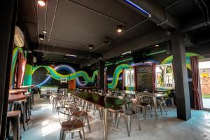 a restaurant with tables and chairs in a room with colorful walls at Mad Monkey Chiang Mai in Chiang Mai