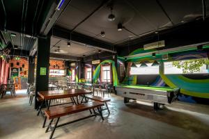a dining room with tables and a pool table at Mad Monkey Chiang Mai in Chiang Mai