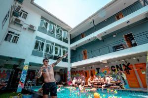 a man standing in a swimming pool with his arm in the air at Mad Monkey Chiang Mai in Chiang Mai