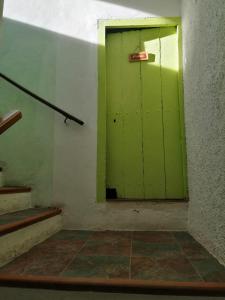 Una puerta verde en una habitación con una escalera en CAL BENAIGES, en 