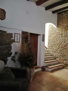 a living room with a brick wall and a wooden door at CAL BENAIGES in Tartareu